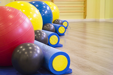 Pilates 类的彩色球和滚滚魔法运动橡皮调色地面平衡有氧运动体操瑜伽滚筒背景图片