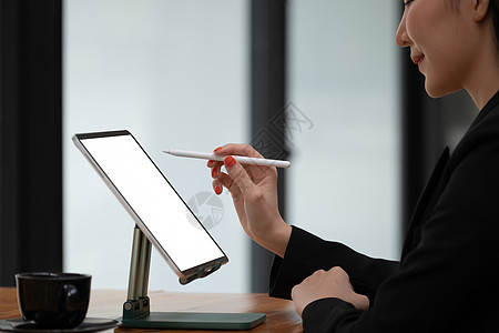 用空白屏幕在木制桌上装上数字平板电脑 通过电视会议举行商业人士会议和集思广益图片