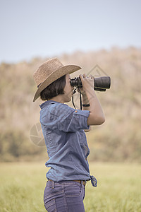 妇女戴帽子 在草地佩戴望远镜旅游森林女孩女性天空绿色冒险活动农村间谍图片