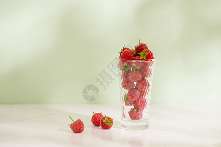 在光背景上隔绝的玻璃杯中的新鲜树莓早餐玻璃浆果饮食水果红色绿色果汁甜点桌子图片