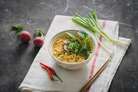 用萝卜 草药和洋葱碗中的即时面条筷子蔬菜午餐香料拉面美食食物图片