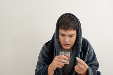 年轻男人得了流感 躺在家里被毯子罩着 吃药疾病压力沮丧治疗药片药品医疗药物男性抗生素图片