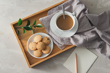 用纸笔和铅笔在白杯盘上加饼干的茶图片