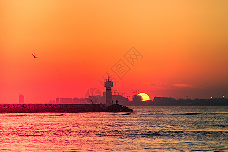 日落和日出金色的天空 与奇幻的暮光灯塔背光橙子晴天气氛云景场景戏剧性阳光光束图片