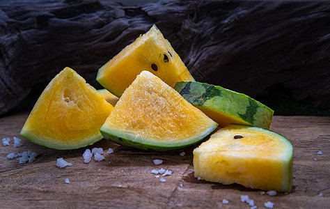 新鲜多汁的黄色西瓜在旧木背景上切成三角形种子食物热带营养农业情调饮食水果静物甜点图片