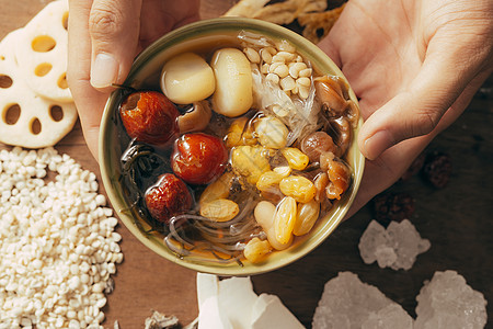 手牵着碗中的清宝梁白色甜点黄色种子美食枸杞食物图片