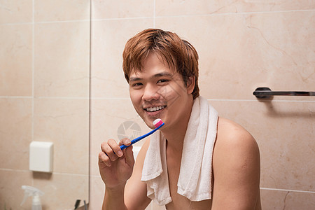 清晨刷牙 有吸引力的年轻人用牙刷刷牙 照镜子看自己 笑声刷子卫生白色牙科男性男人浴室图片