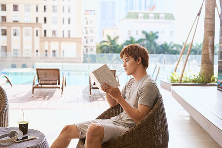 在阳光明媚的夏日 游泳池旁读书的年轻亚洲人花园水池晴天休息男性教育吊床闲暇享受男人图片