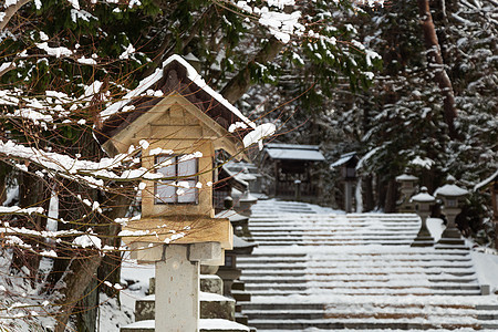 日本石灯笼和木灯笼在冬季飞驒三宫 HieJinja 神社有雪 在岐阜 飞騨高山 日本木头地标旅行石头宗教入口降雪建筑公园森林背景图片