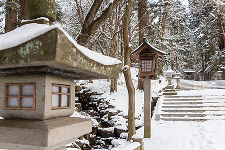 日本石灯笼和木灯笼在冬季飞驒三宫 HieJinja 神社有雪 在岐阜 飞騨高山 日本季节公园建筑学木头三王入口建筑石头森林地标图片