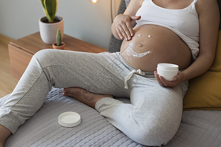 申请奶霜的孕妇女性肚子卧室奶油保湿腹部怀孕休息笑脸皮肤图片
