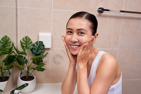 年轻的越南女孩喜欢泡泡洁面泡沫卫生间皮肤浴室女士女性白色清洁护理背景图片