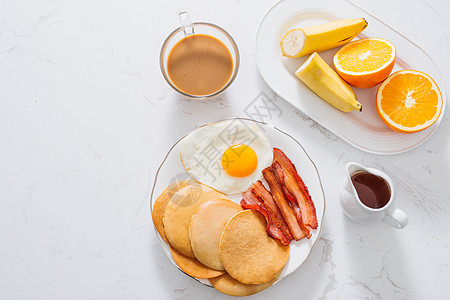 健康全美早餐 配鸡蛋培根和煎饼晴天橙子香蕉谷物杯子食物牛奶咖啡饼子盘子图片
