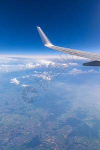 从乘客窗口可以看到蓝天白云下高空飞行的飞机机翼 在欧洲上空飞行 喷气式飞机机翼在蓝天上空飞过云层的视图航班太阳日落天线空气旅游运图片