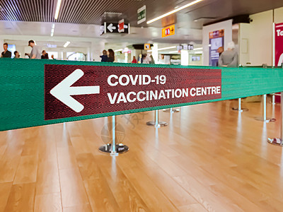 用左箭标明Covid-19疫苗接种中心的绿丝带 以示Covid-19接种中心图片