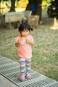 女童在公园里拥有饮用水瓶和跑步的女婴图片