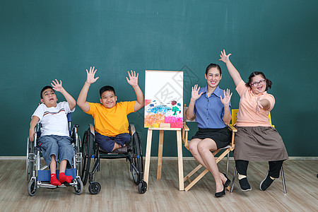 一组残疾和自闭症的年轻女孩正在通过用水绘画和油漆来训练她们的手和手指肌肉 a 教育孩子创造力艺术家喜悦幸福童年画家残障乐趣幼儿园图片