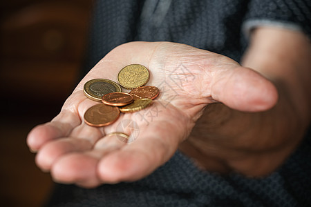 年长老年妇女手上的两枚欧元硬币图片