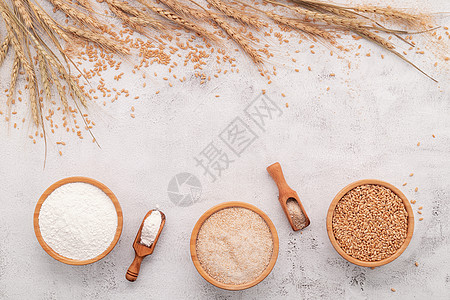 小麦 棕色面粉和在白混凝土底料上安装的木碗中的白面粉谷类糕点谷物化合物产品颗粒剂燕麦粮食烹饪营养图片