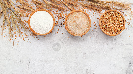 小麦 棕色面粉和在白混凝土底料上安装的木碗中的白面粉谷类粉末碳水稻草大麦面包味道燕麦食物营养图片