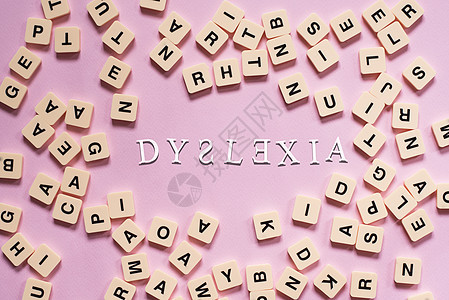 以粉红色背景为中心 DYSLEXIA 单词的字母顺序拼图块错误诊断童年学校诵读症状教育学习智力孩子图片