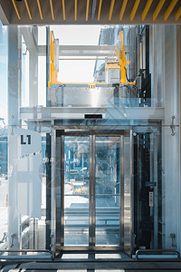 现代电梯和建筑设施的室内建筑 透明电梯的入口门和不锈钢框架 百货大楼装修大堂楼层及电梯门背景