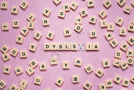 以粉红色背景为中心 DYSLEXIA 单词的字母顺序拼图块智力教育诊断学习帮助学校治疗拼写卫生孩子图片