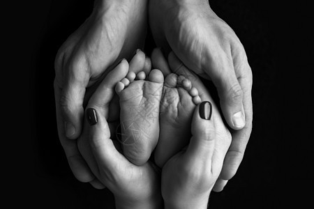 儿童双脚握在父母 母亲 父亲和新生儿的手中 (掌声)图片