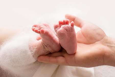 儿童双脚握在父母 母亲 父亲和孩子的手中 幸福家庭的概念 笑声妈妈婴儿投标手指赤脚压痛童年母性皮肤孩子们图片