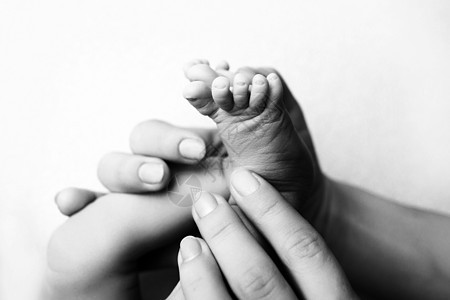 孩子们的脚在白色的母亲和父亲的手上 母亲 父亲和刚出生的孩子 快乐家庭人的概念 黑与白婴儿父母手指家庭母性赤脚新生护理皮肤妈妈图片