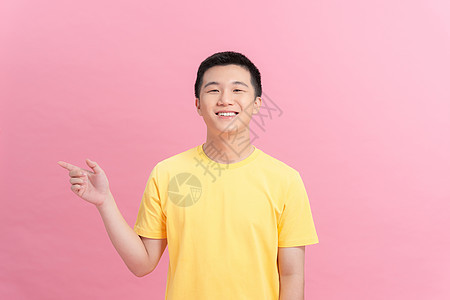 穿着粉红背景孤立的黄色T恤衫 身穿白色短袖圆背面快乐男人手指微笑手势粉色背景图片