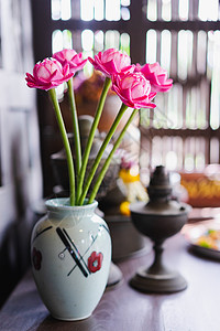 木桌上花瓶里的假花花朵装饰白色植物群粉色制品陶瓷房子房间花束图片