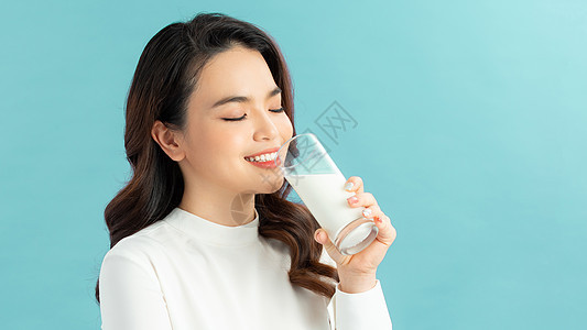 女人喝牛奶时会看镜头成人女士女孩女性牛奶早餐微笑饮料玻璃图片