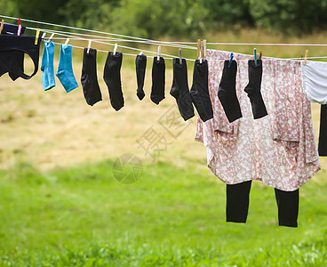 挂在户外绳索上的彩色衣物衣夹蓝色衬衫家庭家务衣服微风天空洗涤剂别针图片