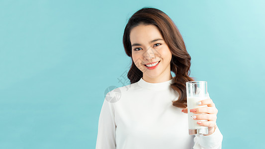 年轻女子喝牛奶杯 女性快乐的微笑 孤立在蓝背景自然有机概念上女士女孩玻璃成人饮料早餐牛奶图片