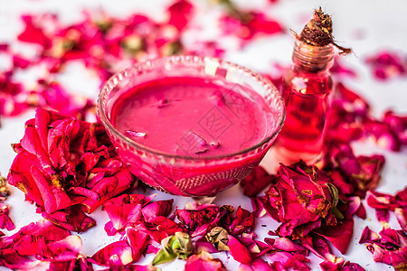 玻璃碗中的玫瑰果酱 在玻璃瓶中加入一些精油或浓缩玫瑰 并在表面撒上一些玫瑰花瓣图片