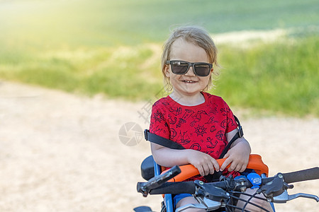 小男孩坐在自行车座椅上图片