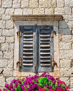 窗口和鲜花框架花园城市砖墙住宅建筑风格村庄石头房子图片