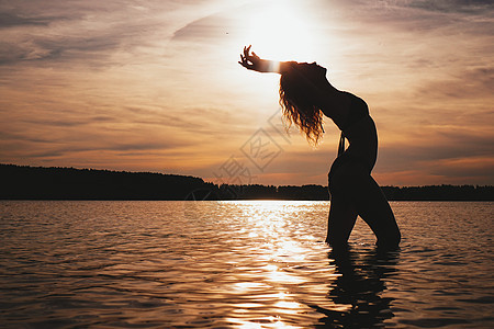 享受海滩上美丽的日落的快乐无忧女女性阳光运动生活假期冲浪女士海洋海浪支撑图片