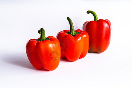 三个红甜椒 白色背景中的红辣椒图片