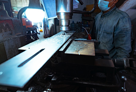 一个男人戴着外科口罩 用铣床工作 用于切割金属工件的工具 带硬质合金铣刀的立式铣床 钢铁制造行业 铣削工艺生产旋转安全面具数控男背景图片