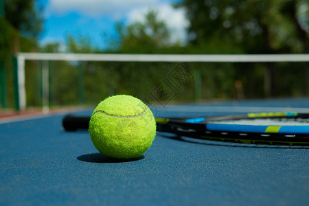 在网球拍打背景上 近距离的黄色球图片