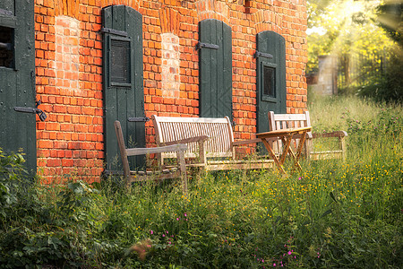 夏天 在红砖屋前的露台上布置了木沙发背景图片
