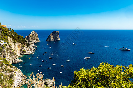紧靠法拉格里奥尼迪梅佐和卡普里岛的小型船只和小船群树木岩石旅行小岛天空石头海岸蓝色灌木丛渡船图片