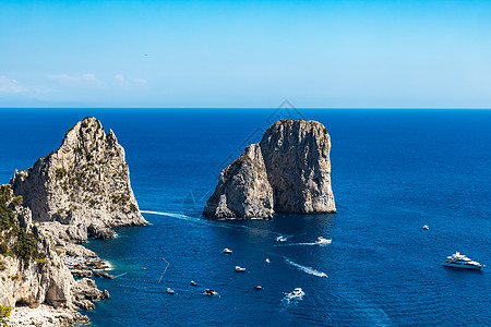 紧靠法拉格里奥尼迪梅佐和卡普里岛的小型船只和小船群海洋石头岩石全景悬崖灌木丛衬套天空假期渡船图片