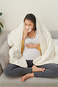 怀孕和寒冷 生病的孕妇 在组织中爆鼻 感觉不舒服坐在家里的小屋沙发长椅医疗母亲女士女性流感肚子腹部母性图片
