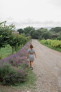 妇女走在紫衣草田边国家季节环境农业紫色旅游场地天空农场园艺图片