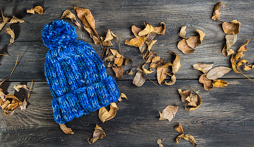 质朴的木质背景和秋假上的手工针织羊毛帽高架材料织物羊毛床单工艺纺织品叶子衣服作品图片