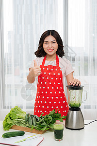 年轻的年青女性在家厨房做绿色解毒冰淇淋女孩蔬菜饮料冰沙女士菠菜水果排毒饮食果汁图片