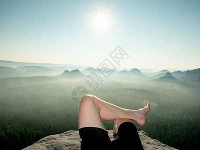 男子赤脚大腿在山顶上放松一下图片
